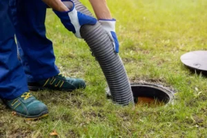 Cleaning a drain surrounded by grass in a field.