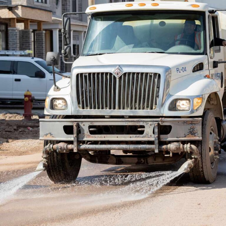 Commercial Road Washing and Road Flushing Truck doing a road washing service on a new housing development site.