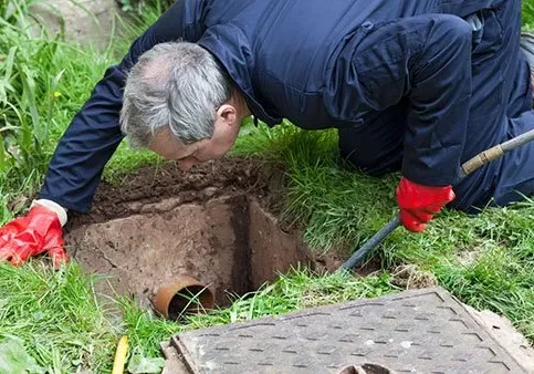 Technician works on exterior drain